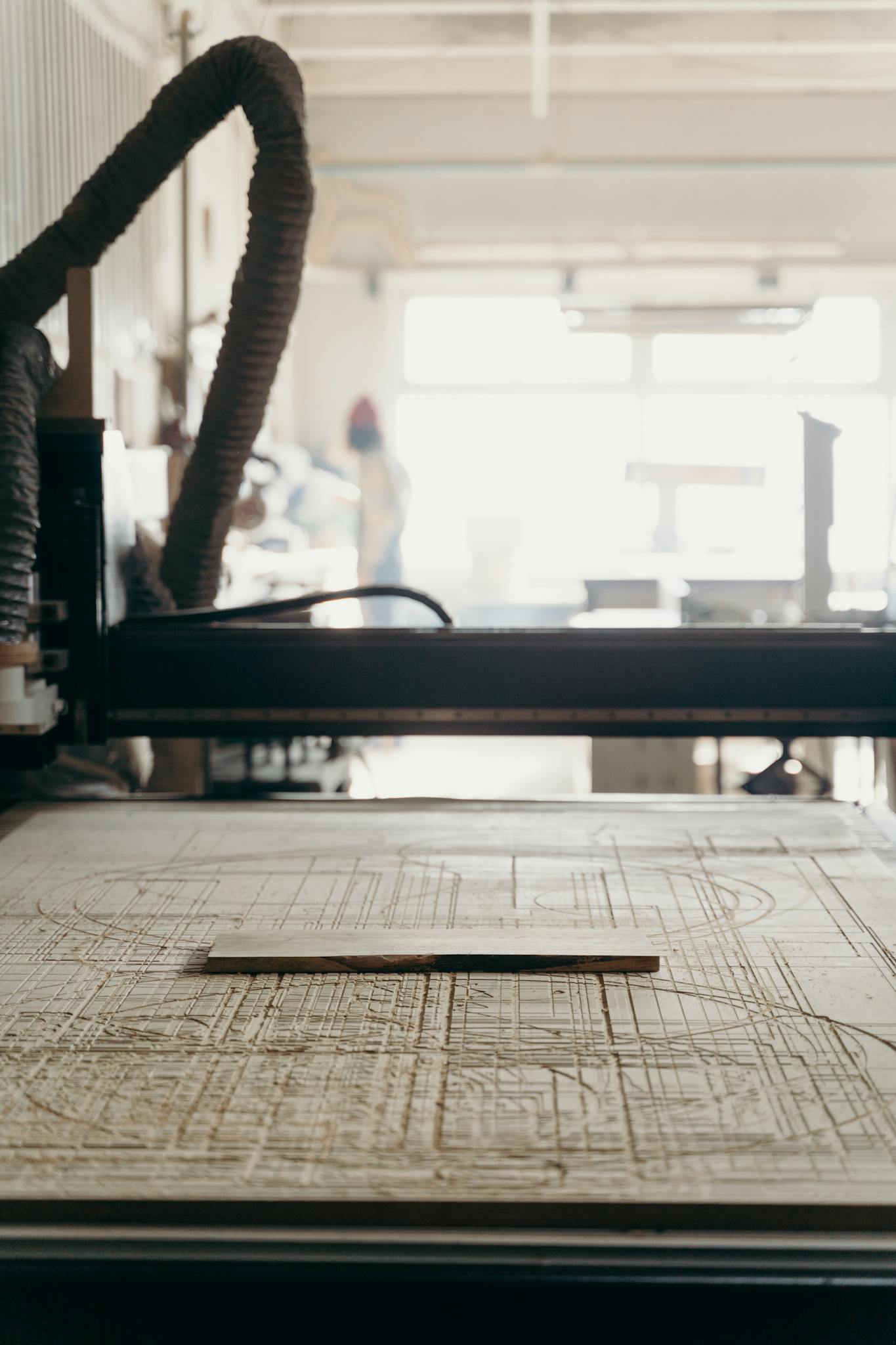 Close-up view of a CNC machine in a workshop, with a focus on the carved details.
